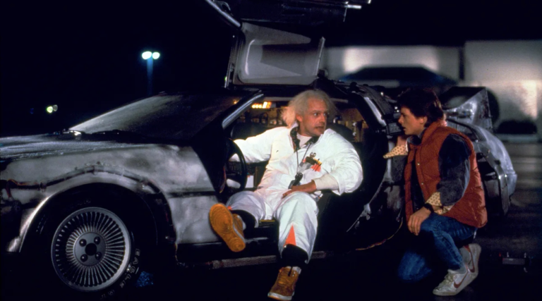 Back to the Future image with Marty McFly and Doc Brown sitting in DeLorean car. 